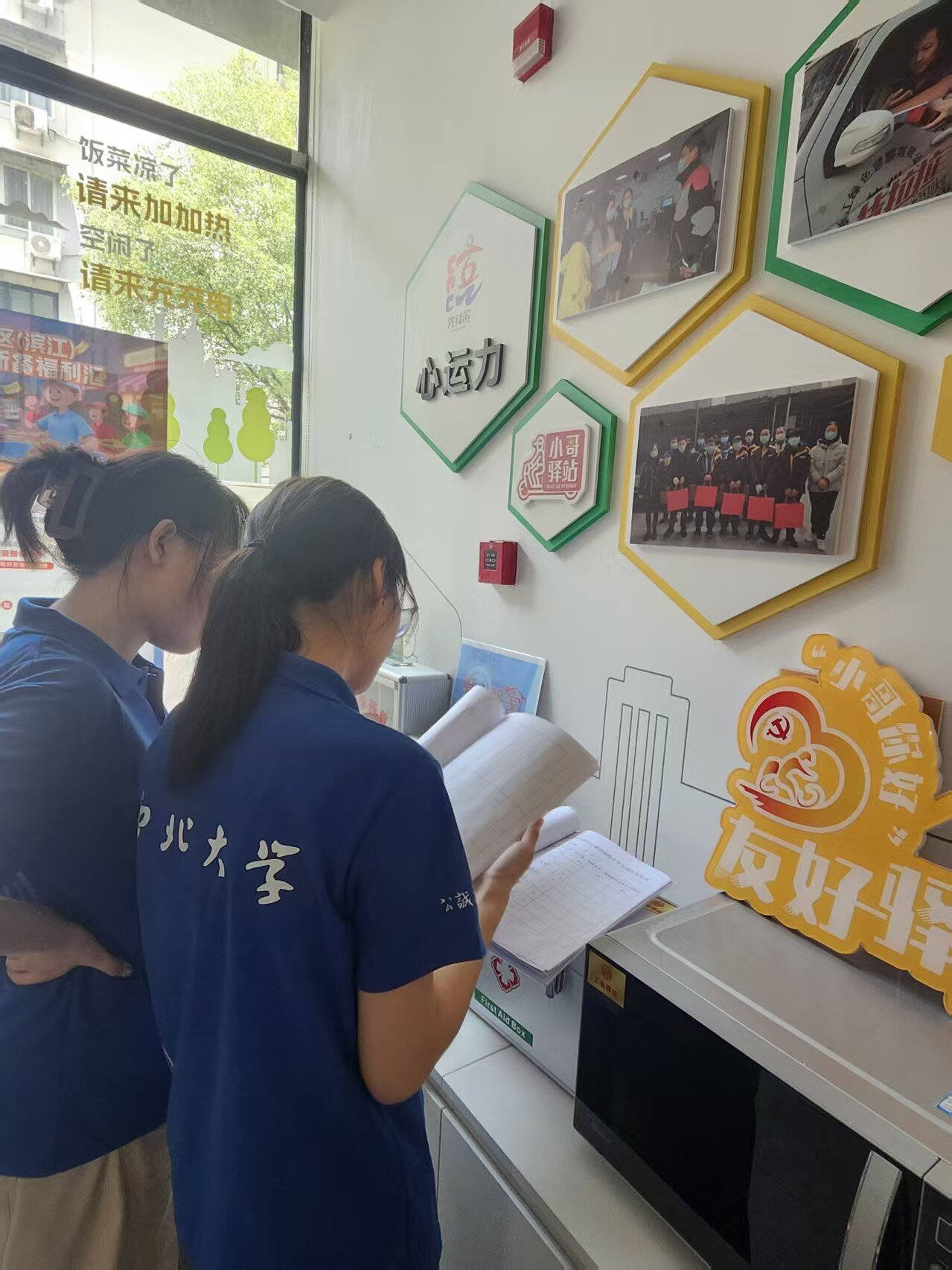 1785564207733532.jpg 图三(团队成员查阅江汉社区小哥驿站的工作台账).jpg